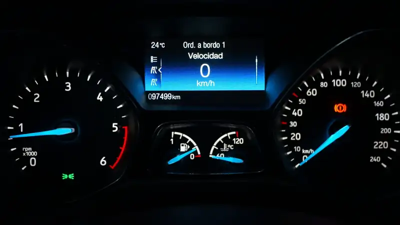 A car's lit instrument cluster at night: tachometer, speedometer, fuel gauge and an odometer reading.